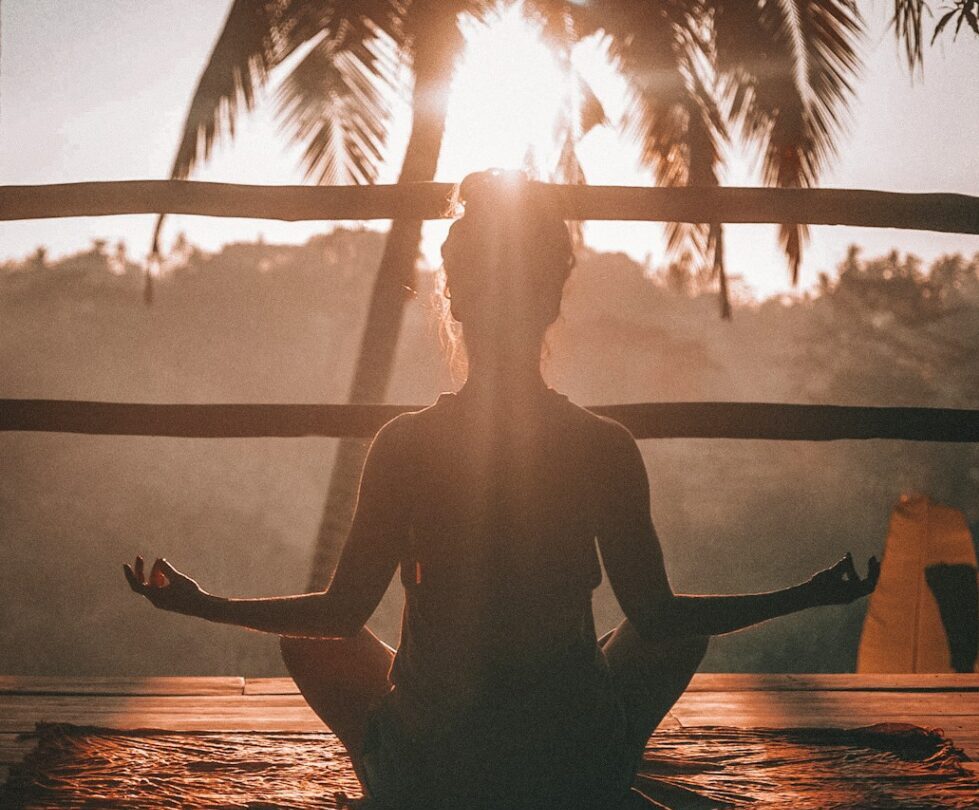 woman doing yoga meditation on brown parquet flooring